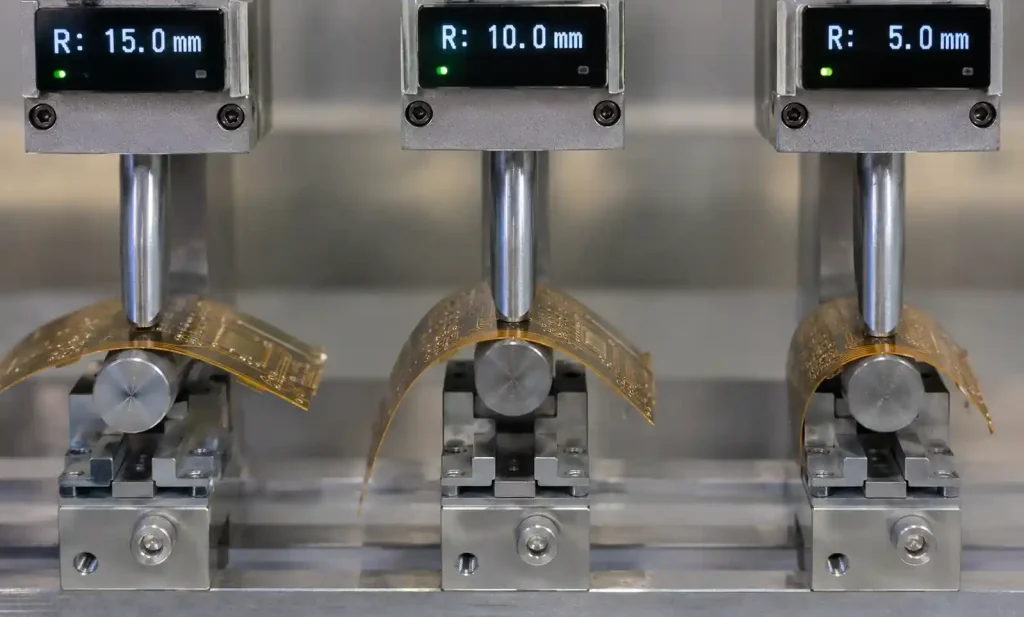 Flexible PCB undergoing dynamic bend radius testing showing proper and improper bending configurations