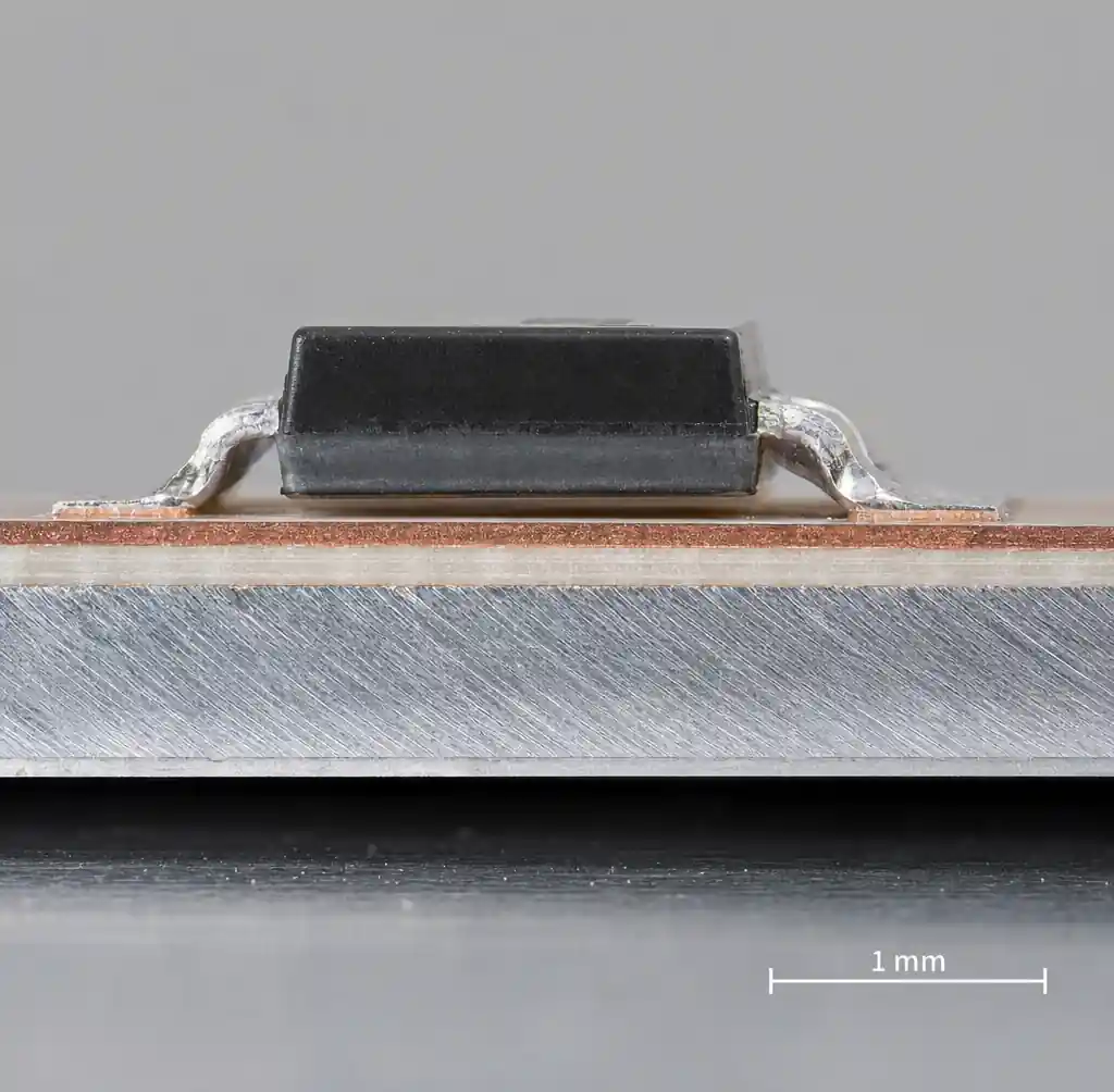 Cross-section of a metal core PCB showing copper circuit layer, dielectric, and aluminum base under a power component