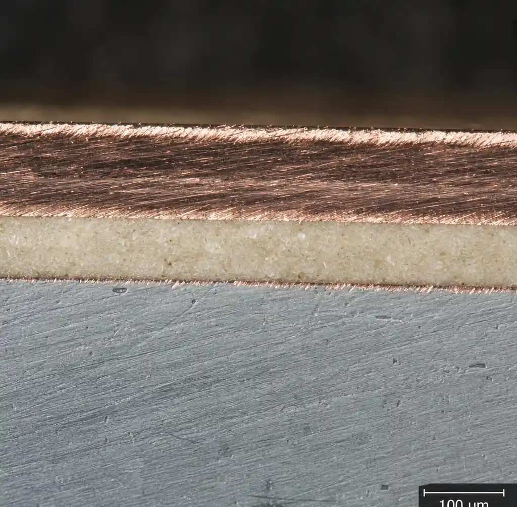Close-up of the thermally conductive dielectric layer bonding copper foil to the aluminum base of an MCPCB