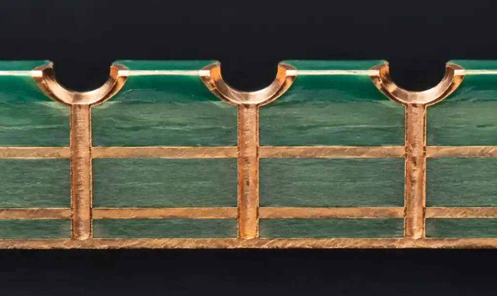 PCB edge plating showing castellated holes with copper plating on vertical sidewalls