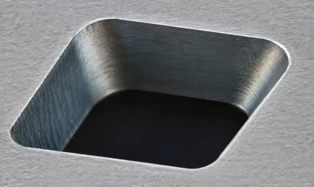 Microscope photograph of laser-cut stencil aperture showing smooth walls and proper taper angle